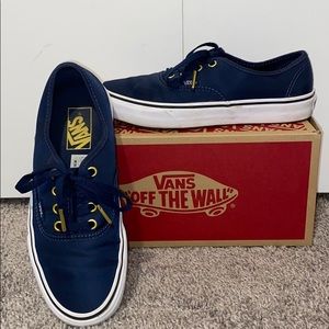 Navy blue vans with gold accents.